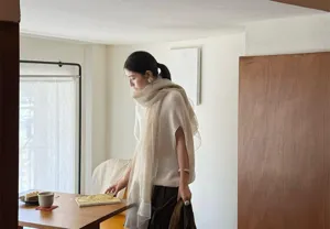 Elegant beige wool and mulberry silk lightweight scarf shawl shown on a model indoors