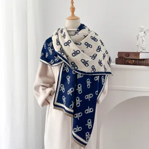 Detailaufnahme eines doppelseitigen Jacquard-Schals mit Buchstaben und dekorativen Fransen