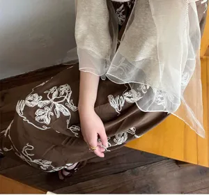 Close-up detail of a beige lightweight wool silk scarf shawl with translucent texture