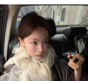 Elegant beige lightweight wool and silk scarf worn by a stylish woman in a car interior