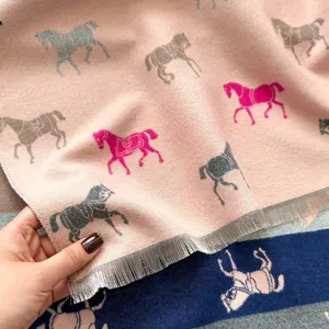 Macro-detail van zachte imitatie kasjmier sjaal met kleurrijk paardenpatroon en franjes