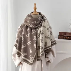 Elegante Detailansicht des dicken Jacquard-Buchstaben-Schals mit Fransen auf einer Schaufensterpuppe