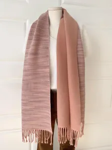 Detailansicht eines doppelseitigen rosa gestreiften Schals mit Fransen an einer Puppe