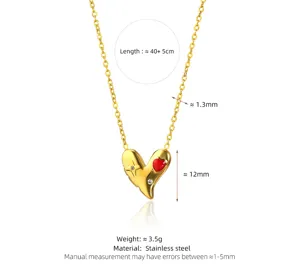 Detalle del collar de corazón asimétrico dorado con incrustación roja y medidas en acero.