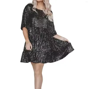Detailed view of black sequin short sleeve dress fabric, sparkling texture and tier hem.