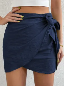Minifalda cruzada de talle alto azul marino con lazo lateral para vacaciones en la playa.
