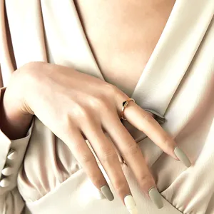 Vue détaillée d'une bague à motif ondulé doré avec un mini charme de serrure au doigt