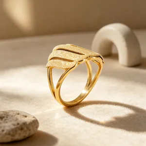 Vista detallada de anillo dorado con diseño de superficie mate de arena brillante