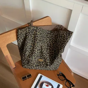 Stylish leopard print canvas tote bag, large capacity casual shoulder bag for women daily use.