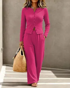 Detail view of a stylish pink ribbed knit cardigan and wide-leg trouser set for women.