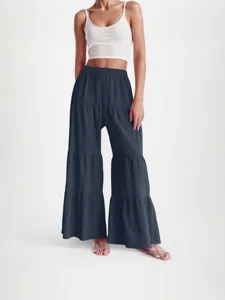 Detail view of the tiered wide-leg pants featuring pleated fabric and comfortable elastic waist.