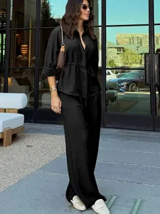 Elegant black long sleeve button down shirt and matching loose trousers two piece set for women.