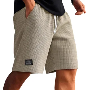 Men's casual waffle knit shorts with drawstring and woven label for summer outdoor wear.