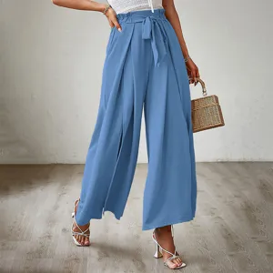 Close-up view of high-waisted pleated wide-legged trousers featuring a cute bow tie detail in blue.