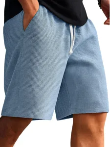 Detail view of men's light blue waffle knit casual shorts with white drawstring waist design.