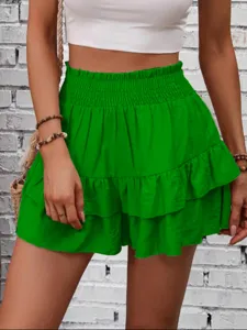 Detail view of vibrant green tiered ruffle skorts featuring elastic high waist and flowy layered design.