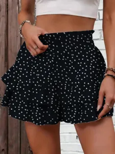 Close-up of black polka dot ruffled tiered shorts with smocked high waist design.
