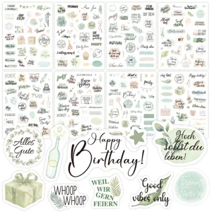 Close-up detail of watercolor birthday stickers in English and German for scrapbooking
