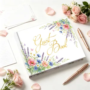 Primo piano di un elegante libro degli ospiti floreale con scritte in oro e penne oro rosa