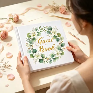 Dettaglio del libro degli ospiti di nozze floreale tenuto su una scrivania elegante