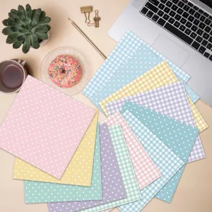 Detailed view of 13 pastel polka dot and gingham scrapbook paper sheets on a desk