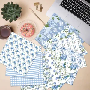 Detailed overhead view of 13 blue and white floral scrapbook papers for DIY crafts