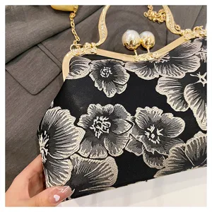 Detail shot of Chinese style floral embroidered handbag with gold frame and pearl clasp