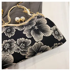 Close-up of exquisite floral embroidery and pearl handle on a vintage Chinese style bag