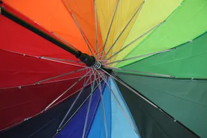 Vista dettagliata della struttura interna dell'ombrello arcobaleno con robuste stecche in metallo.