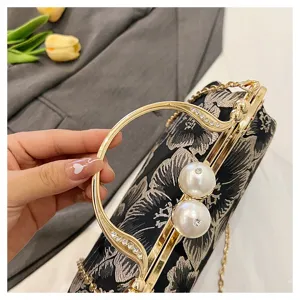 Close-up of pearl clasp and floral embroidery on a vintage Chinese style evening bag