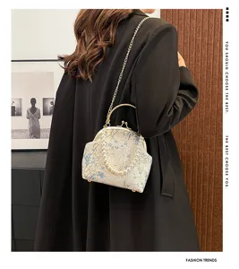Detailed view of a vintage floral silk clutch with pearl handle and gold chain.