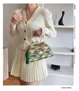 Dettaglio di una borsa in tessuto stile cinese vintage con nappa verde.