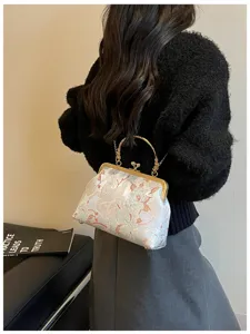 Dettaglio di un'elegante borsa a conchiglia ricamata con fiori e chiusura dorata