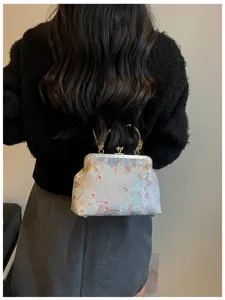 Modella che indossa una borsa ricamata in stile cinese con eleganti motivi floreali