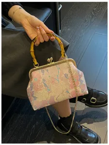 Dettaglio del ricamo floreale e del manico in bambù su una borsa a conchiglia elegante