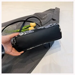 Detail view of the handbag showing the smooth black base and plush floral texture.