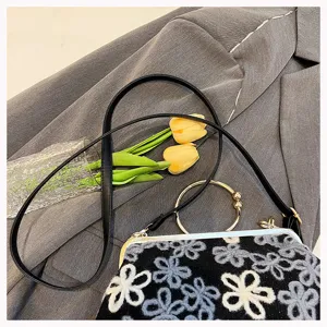 Detail view of vintage velvet handbag with floral sequin embroidery and gold handle