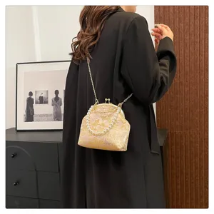 Elegant vintage silk floral bag with pearl handle and gold chain strap worn by model