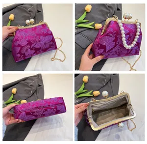 Detailaufnahmen einer lila bestickten Vintage-Handtasche mit Perlenverschluss