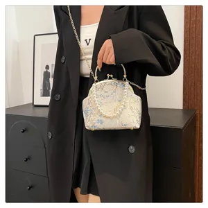 Elegant vintage silk floral frame bag with pearl handle and gold chain strap on model