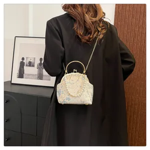 Elegant back view of model carrying a vintage floral silk crossbody bag with pearl handle