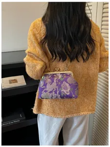 Dettaglio ricamo floreale su una borsa da sera in stile cinese viola con catena