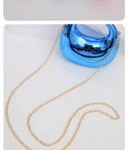 Detailed view of the glossy blue mini crescent acrylic crossbody bag with a gold chain strap.