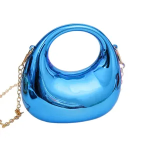 Glossy blue acrylic crescent mini bag with gold chain strap, stylish crossbody handbag.