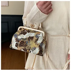 Elegante borsa a conchiglia ricamata con motivo gru e dettaglio chiusura in metallo oro