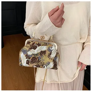 Dettaglio del ricamo vintage della gru su una borsa a conchiglia con chiusura