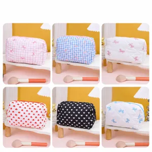 Quilted cosmetic bag with cute bow and heart patterns, portable fabric makeup storage pouch.