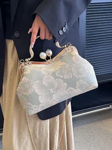 Vintage embroidered floral clutch bag with pearl clasp and gold-tone chain strap.