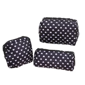 Black quilted makeup bag set with cute white hearts pattern, portable travel cosmetic organizer.