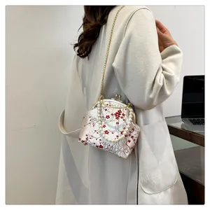 Detailed shot of the silk floral pattern bag featuring a pearl handle and chain.
